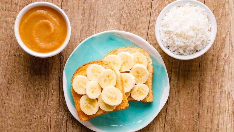 Chế độ ăn BRAT bao gồm: chuối, cơm, táo và bánh mì nướng