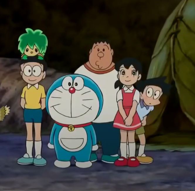 Doraemon đứng cạnh nhóm bạn trước hang động lớn