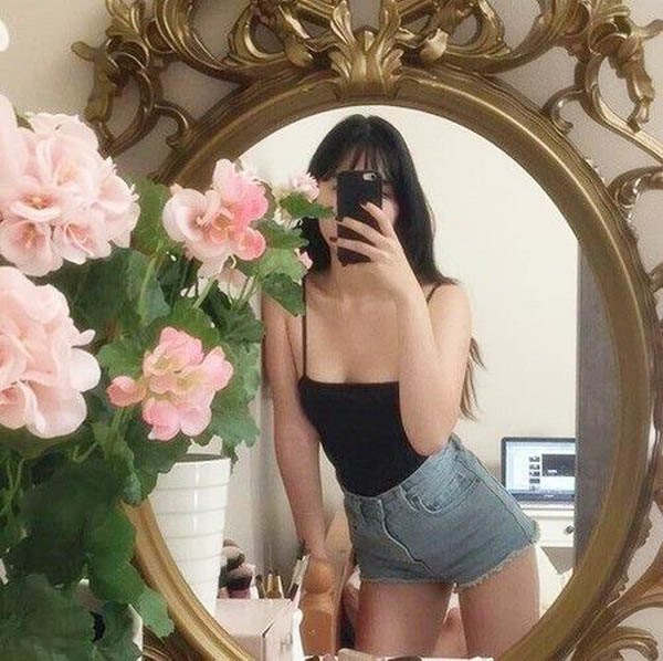 Chị em nên decor một số phụ kiện gần gương như lọ hoa để shot hình thêm phần xinh xắn. Khi chụp ảnh có thể đứng nghiêng người một bên như cô nàng này giúp tôn đường cong cơ thể.