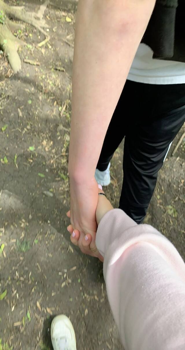 Chụp ảnh tay cặp đôi nắm tay khi đi bộ trên phố lãng mạn