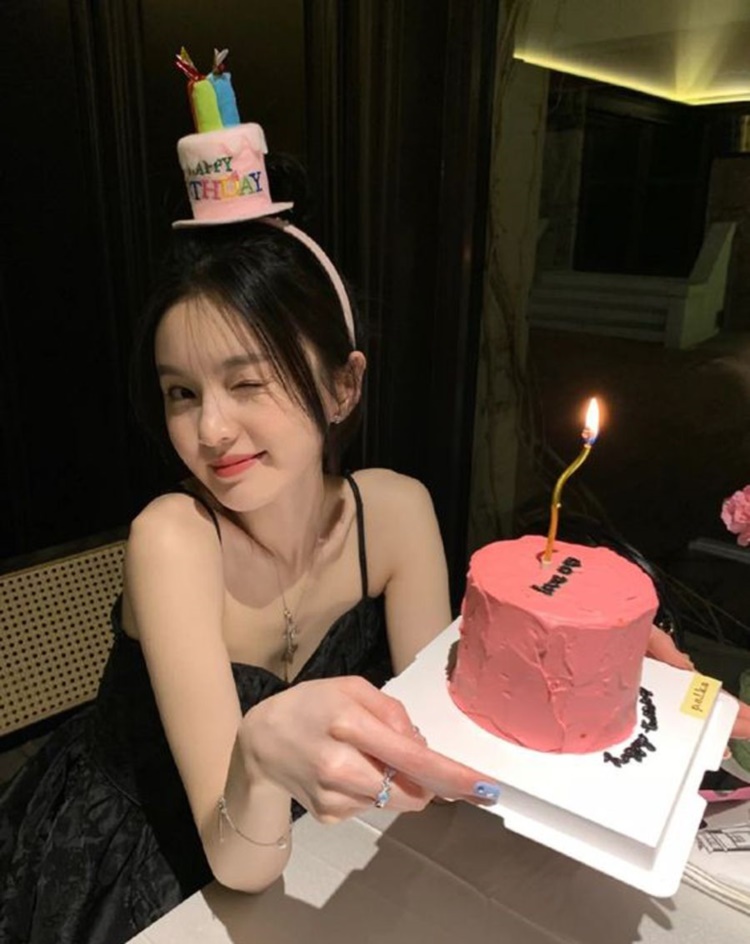 Tạo dáng cầm đồ uống và nhìn sang hướng khác