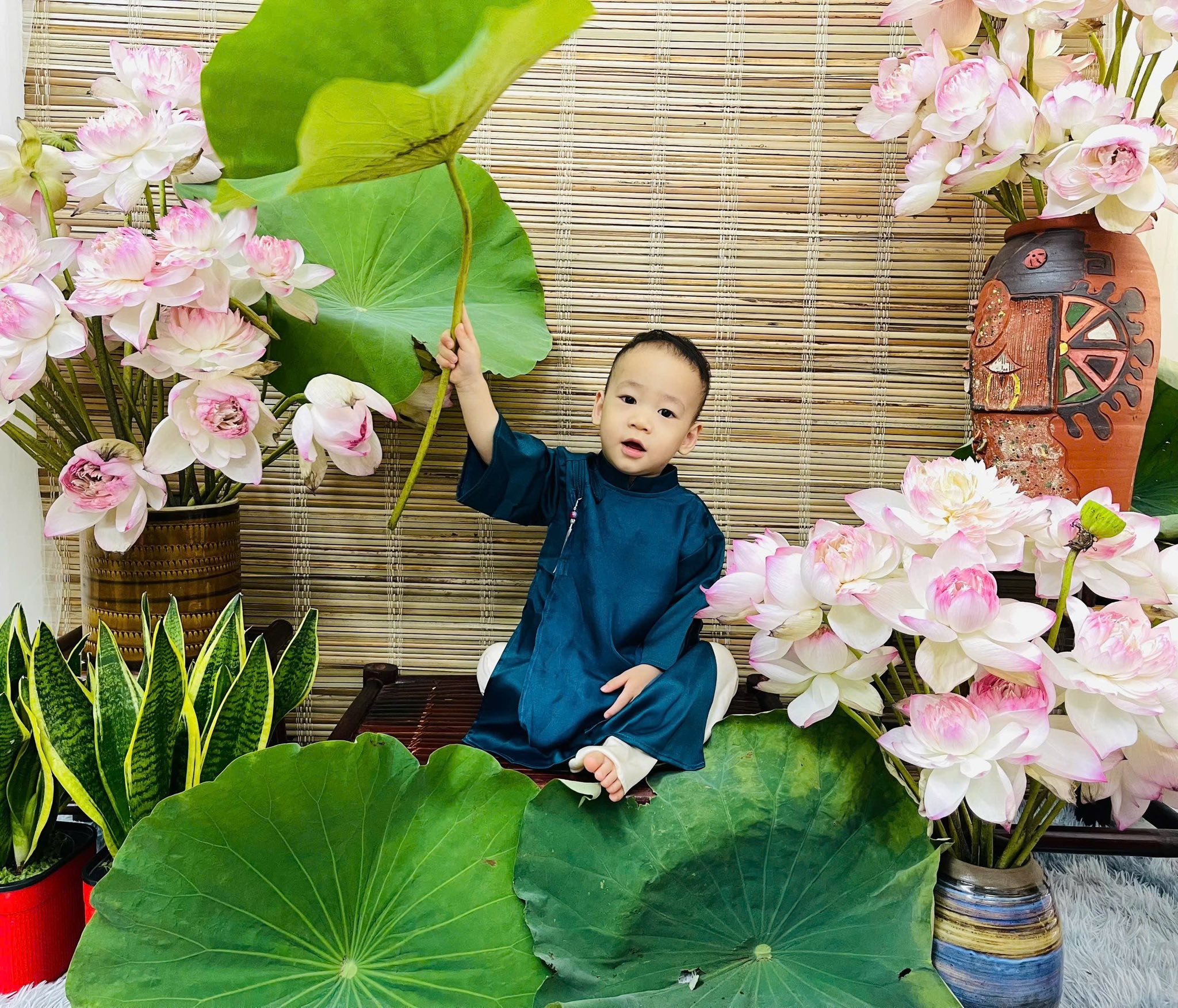 Bé trai mặc áo dài chụp hoa sen