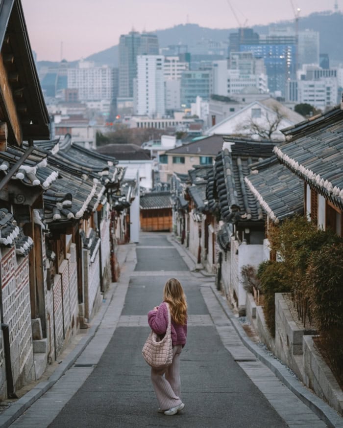 Historic hanok village alley in Seoul and Michelle standing in the center of the empty road