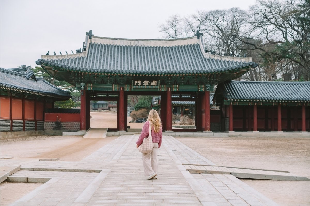 Michelle mid-step at Changdeokgung Palace in Seoul on a stone walkway