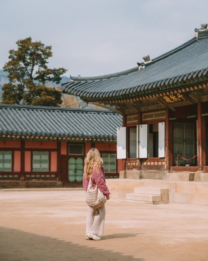 Michelle walking past hanok building in palace complex