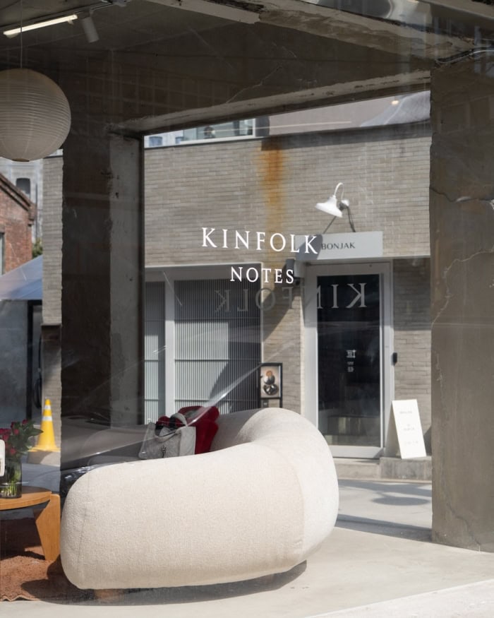Store window for Kinfolk Notes with big white curved couch in the window