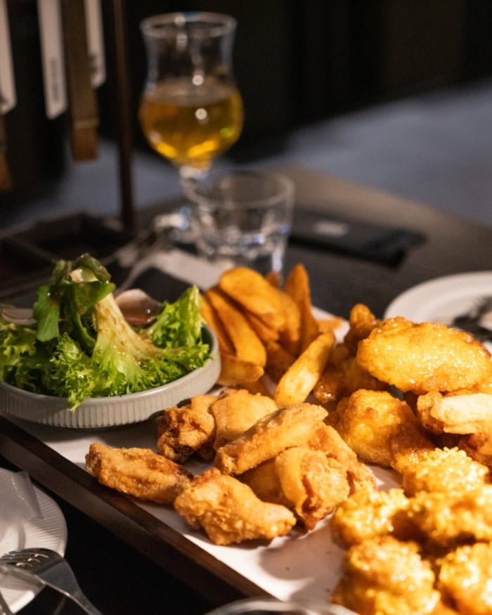 Korean fried chicken with sauces and greens