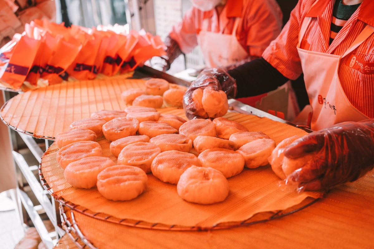 Plate of dumplings behind placed down by two women