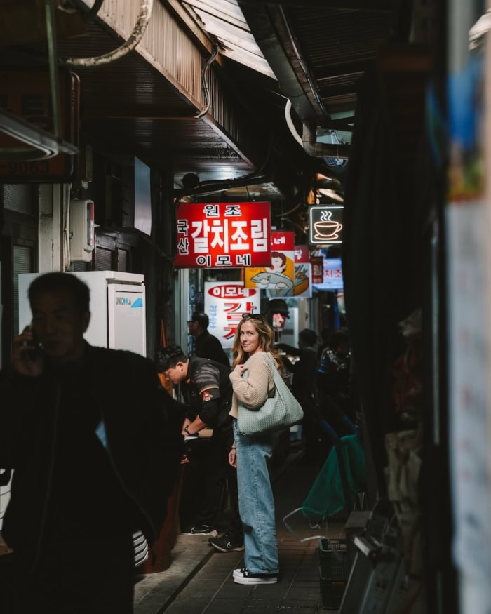 Michelle Halpern standing in a market alley with passerby walking through