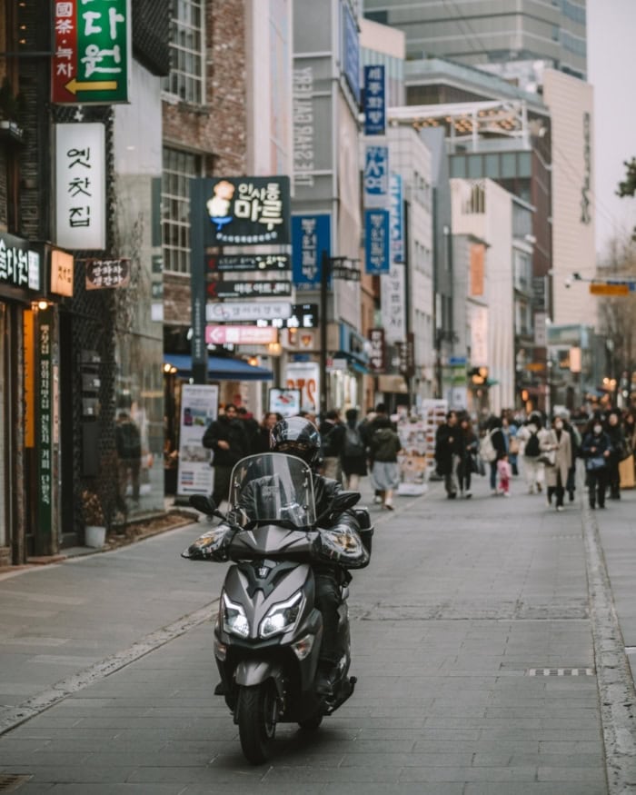 Busy Seoul street with people and scooters