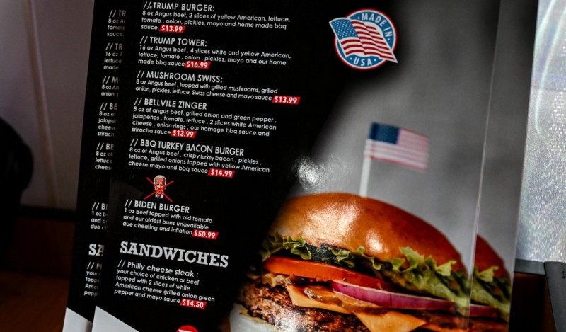 Món Biden Burger mang tính châm biếm, gồm 28g thịt bò, “cà chua già” và “bánh mì cũ”, được niêm yết giá 50,99 USD nhưng chú thích “không có sẵn vì gian lận và lạm phát.”