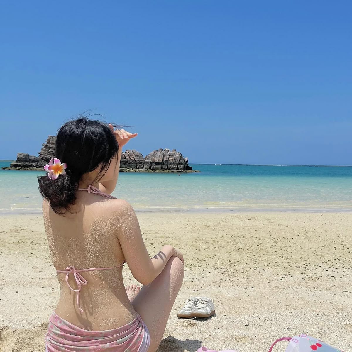 Tạo dáng ngồi gập chân trên khăn trải bãi biển