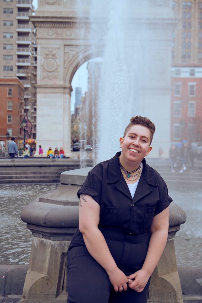 Samantha Golub sitting on fountain in Washington Square Park