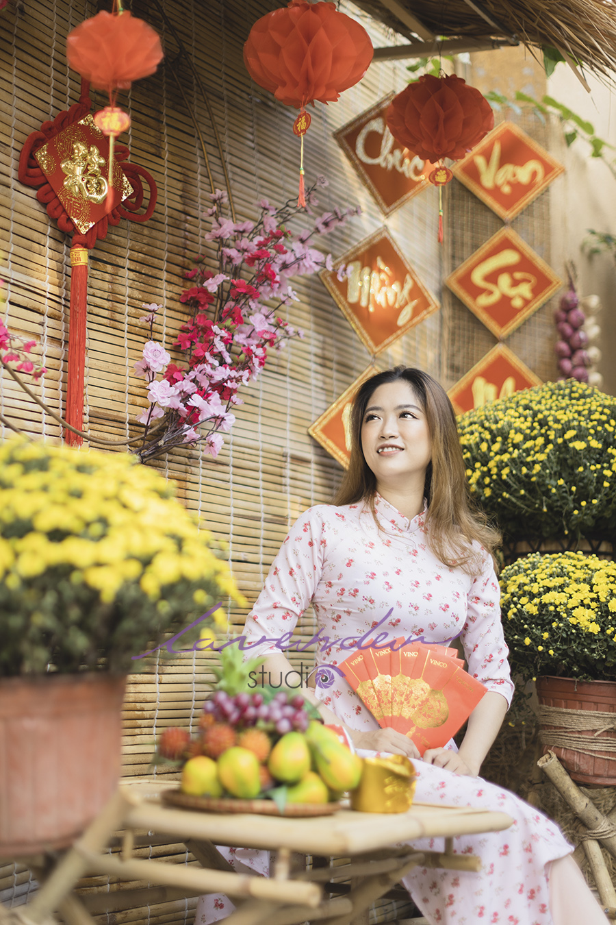 Tạo dáng chụp ảnh áo dài Tết ngồi bên cạnh bình hoa