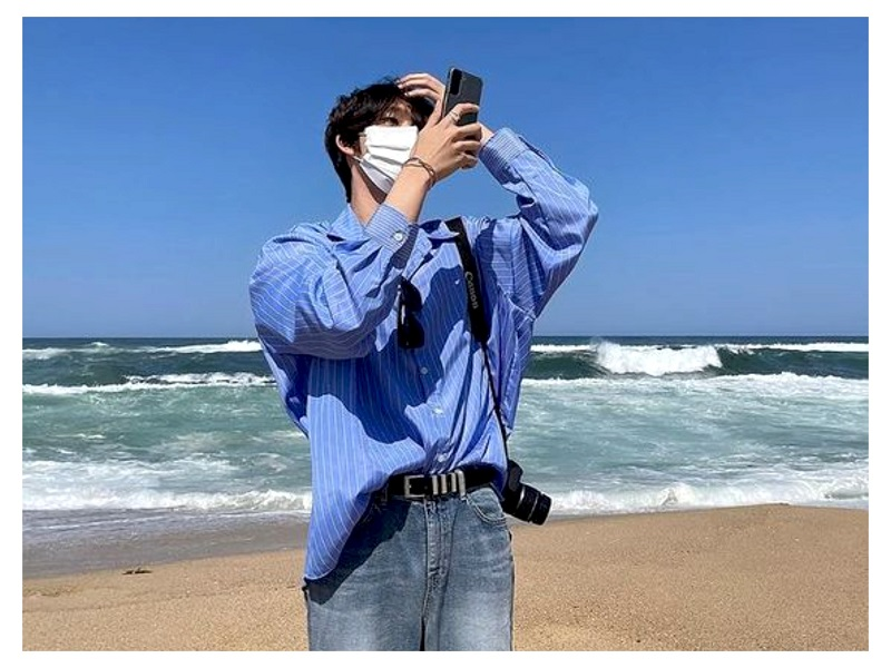 Tạo dáng chụp ảnh nam đi biển với máy ảnh