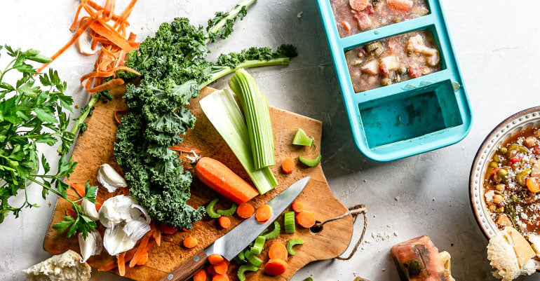 Cutting board full of ingredients next to a Souper Cubes tray.