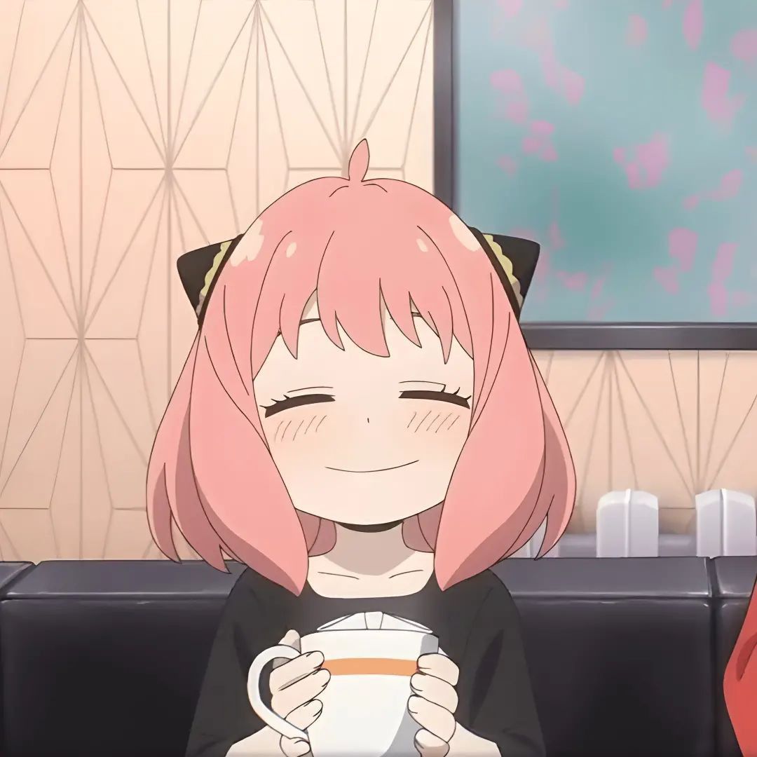 Anya cầm ly sữa mỉm cười dễ thương