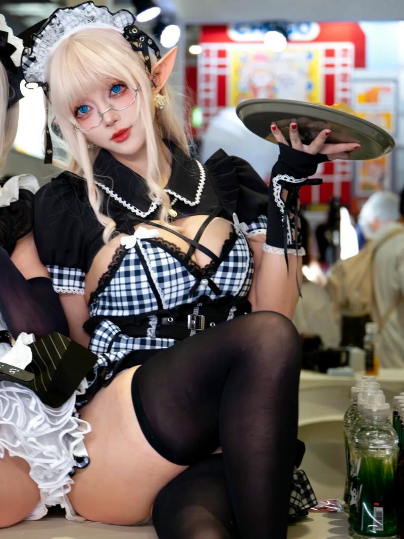 Cosplay hầu gái tóc vàng ngồi trên bàn rất quyến rũ