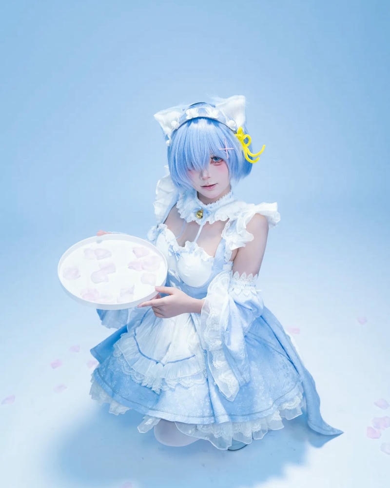 Cosplay hầu gái tóc xanh ngồi cầm đĩa bánh ngọt xinh