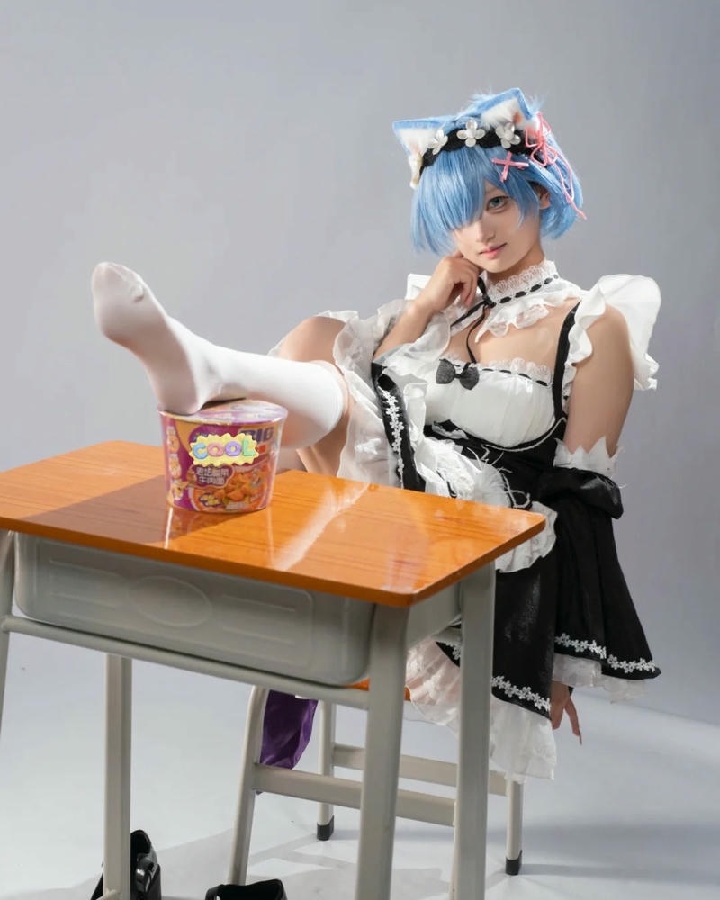Cosplay hầu gái tóc xanh Rem ngồi trên bàn học sinh