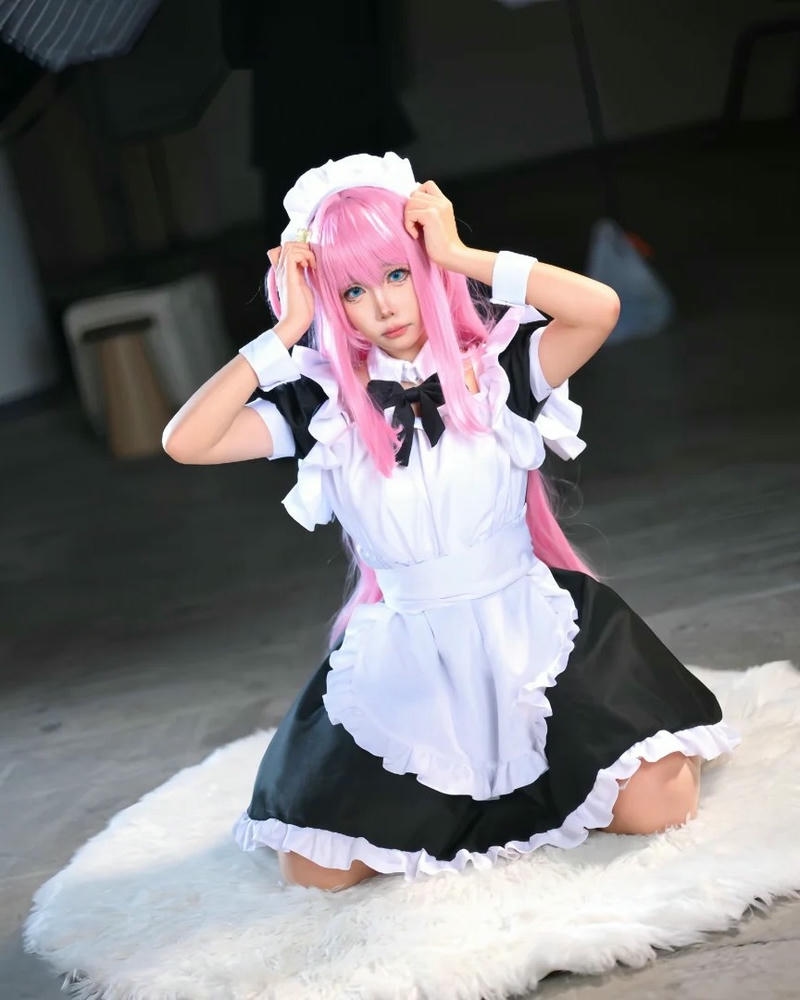 Maid tóc hồng quỳ gối trên thảm lông trắng mềm mại