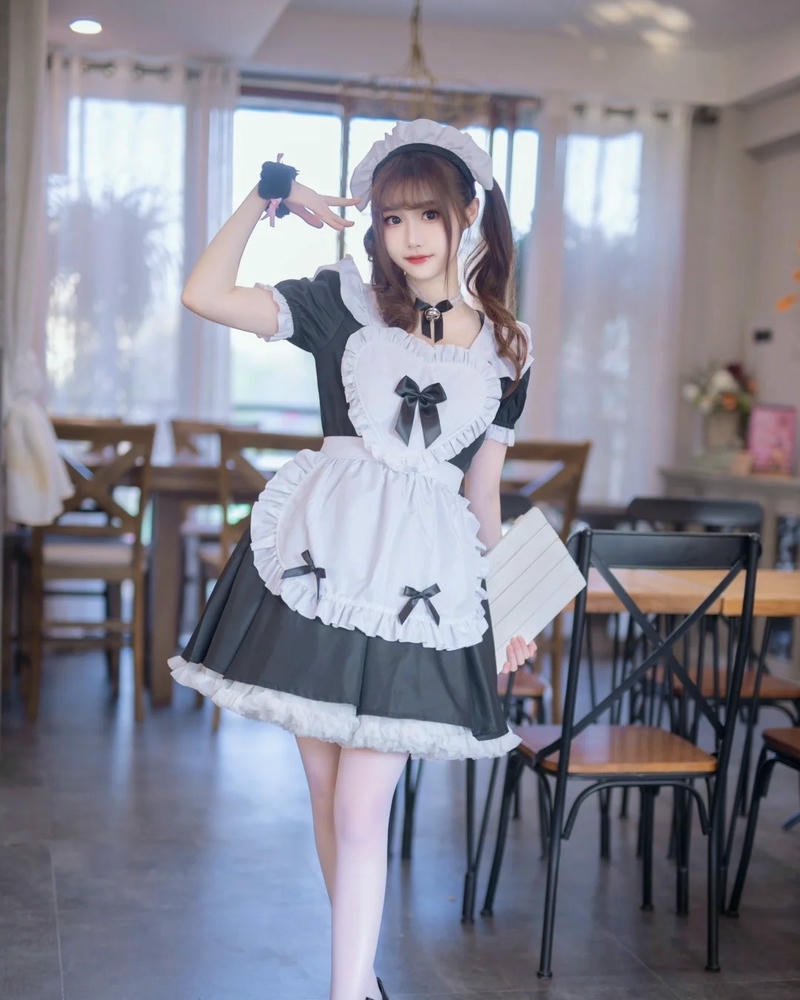 Maid tóc ngắn đứng giữa phòng ăn rộng rãi thoáng mát