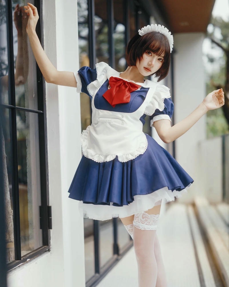 Trang phục hầu gái xanh đứng bên cửa sổ nắng đẹp