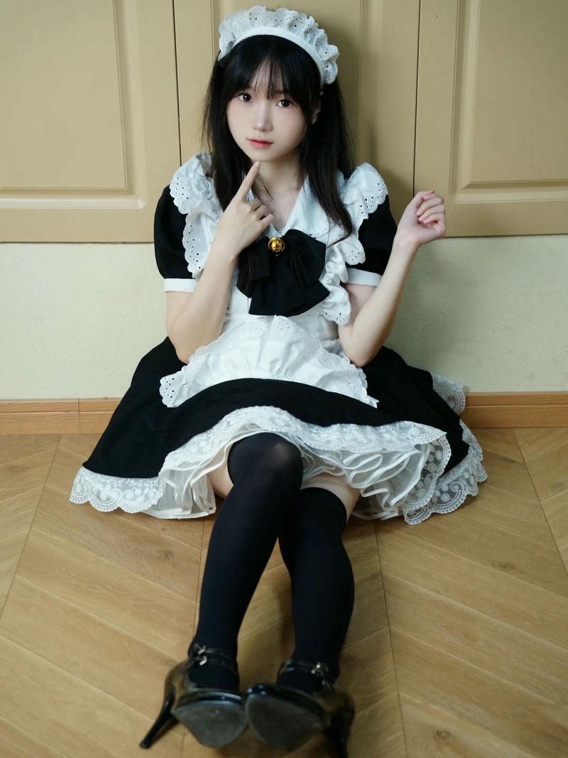 Cosplay hầu gái tóc đen ngồi bệt nhìn thẳng ống kính