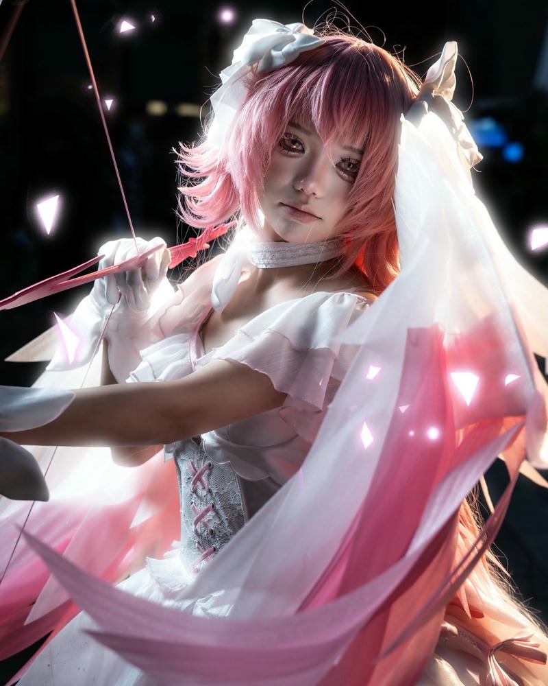 Cosplayer nữ anime tóc hồng váy trắng cầm cung tên dài