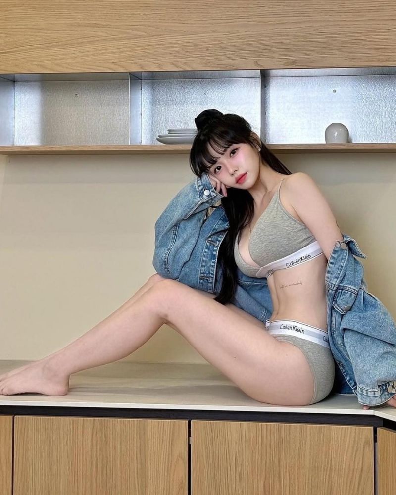 Gái xinh cởi áo khoe bộ bikini xám ngồi trên bàn bếp