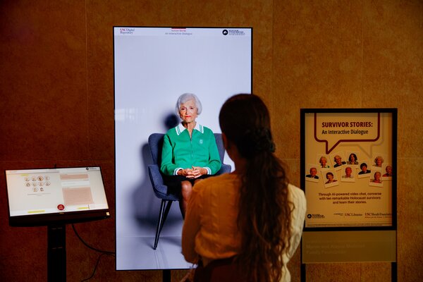 A screen with Toby Levy, a Holocaust survivor.