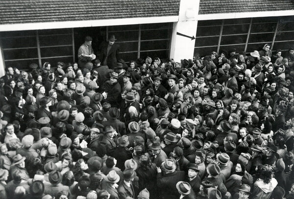 A black-and-white photograph of Hungarian Jewish refugees in front of the Glass House.