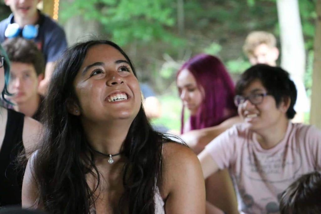 Two teens, one is sharing a concept with hand gestures, the other listens