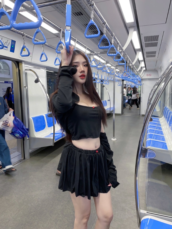 Outfit đen nổi bật giữa không gian tàu điện.