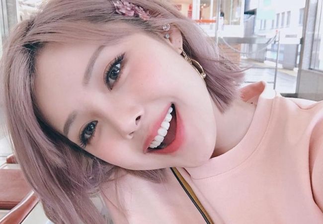 Tạo dáng nghiêng đầu và cười mỉm